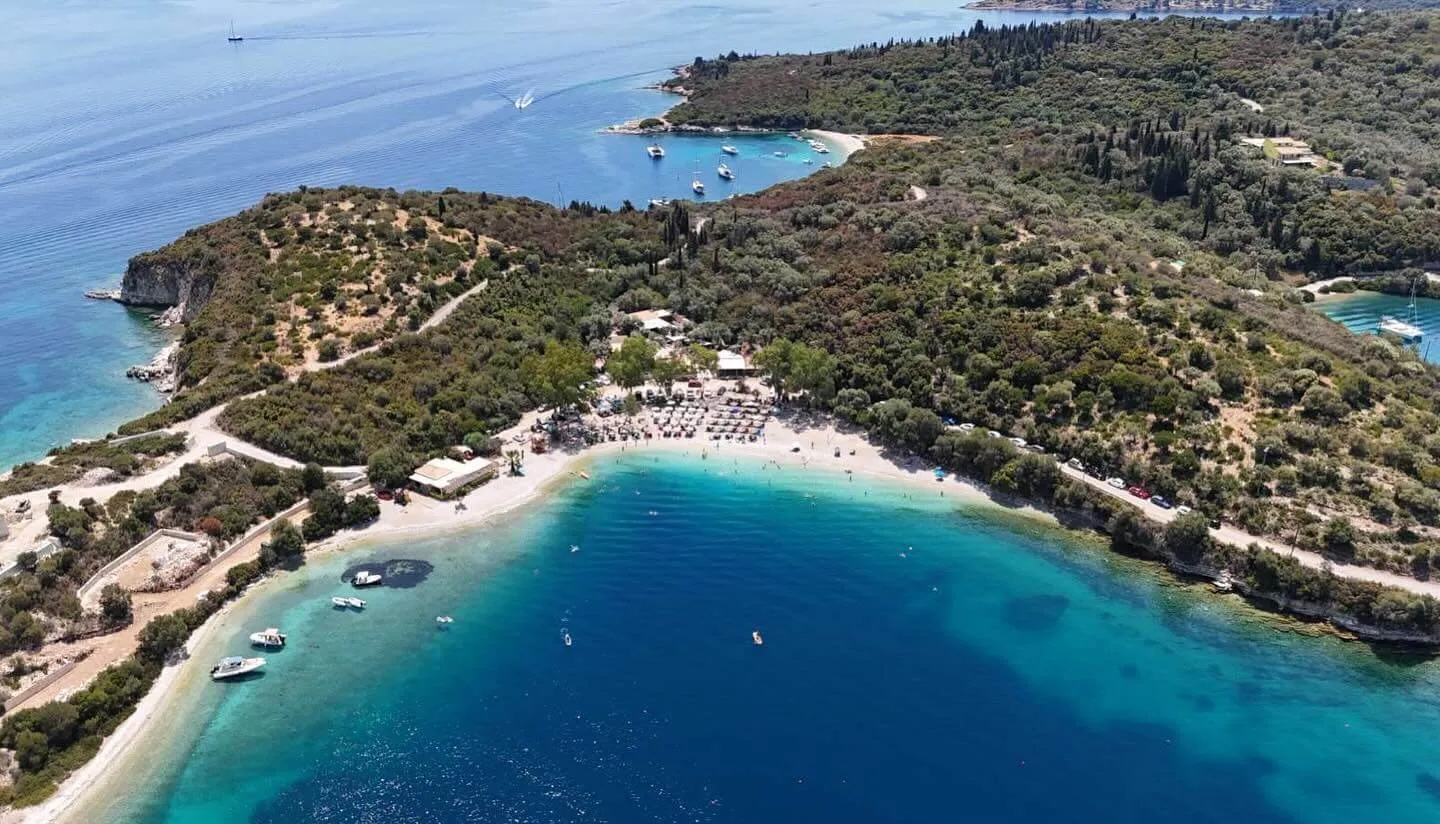Το πανέμορφο και χαλαρωτικό σκηνικό του Blue Beach Bar στο Μεγανήσι, με άνετες ξαπλώστρες και καθαρά τυρκουάζ νερά.
