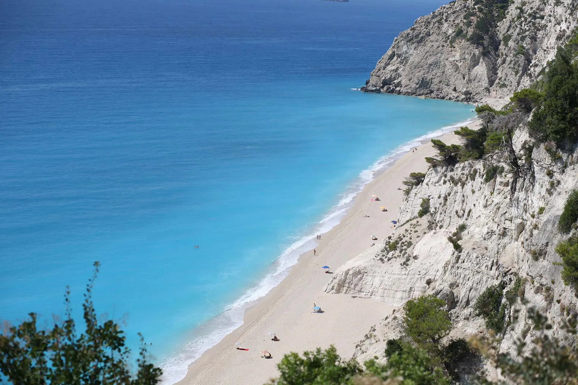 The breathtaking view of the long, sandy Egremni Beach and its iconic turquoise waters, framed by dramatic white cliffs.