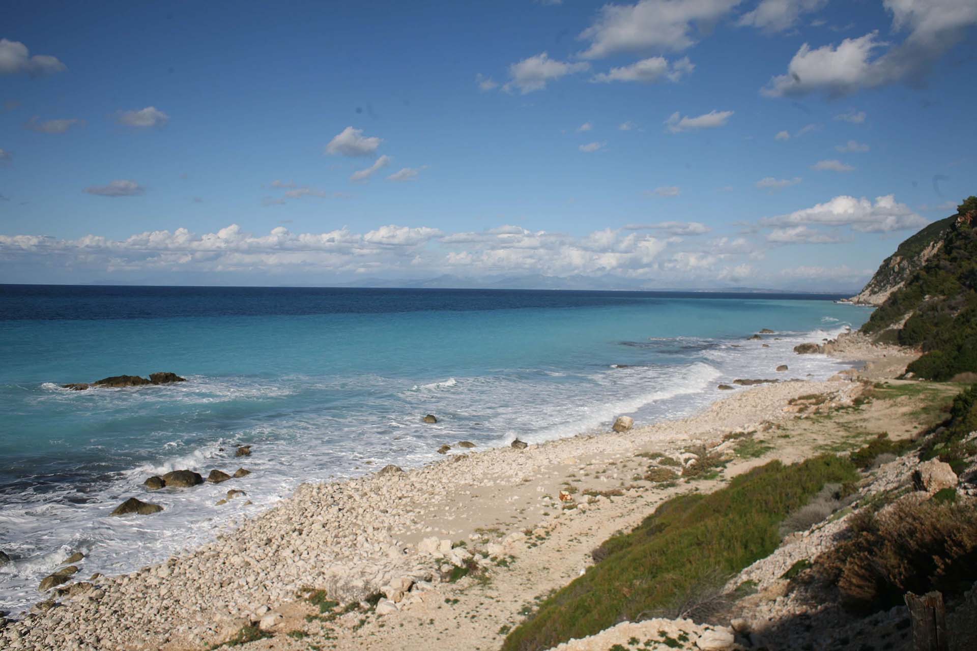 The serene and unspoiled beauty of Skala Gialou Beach, with its pebble shore and clear turquoise Ionian sea.