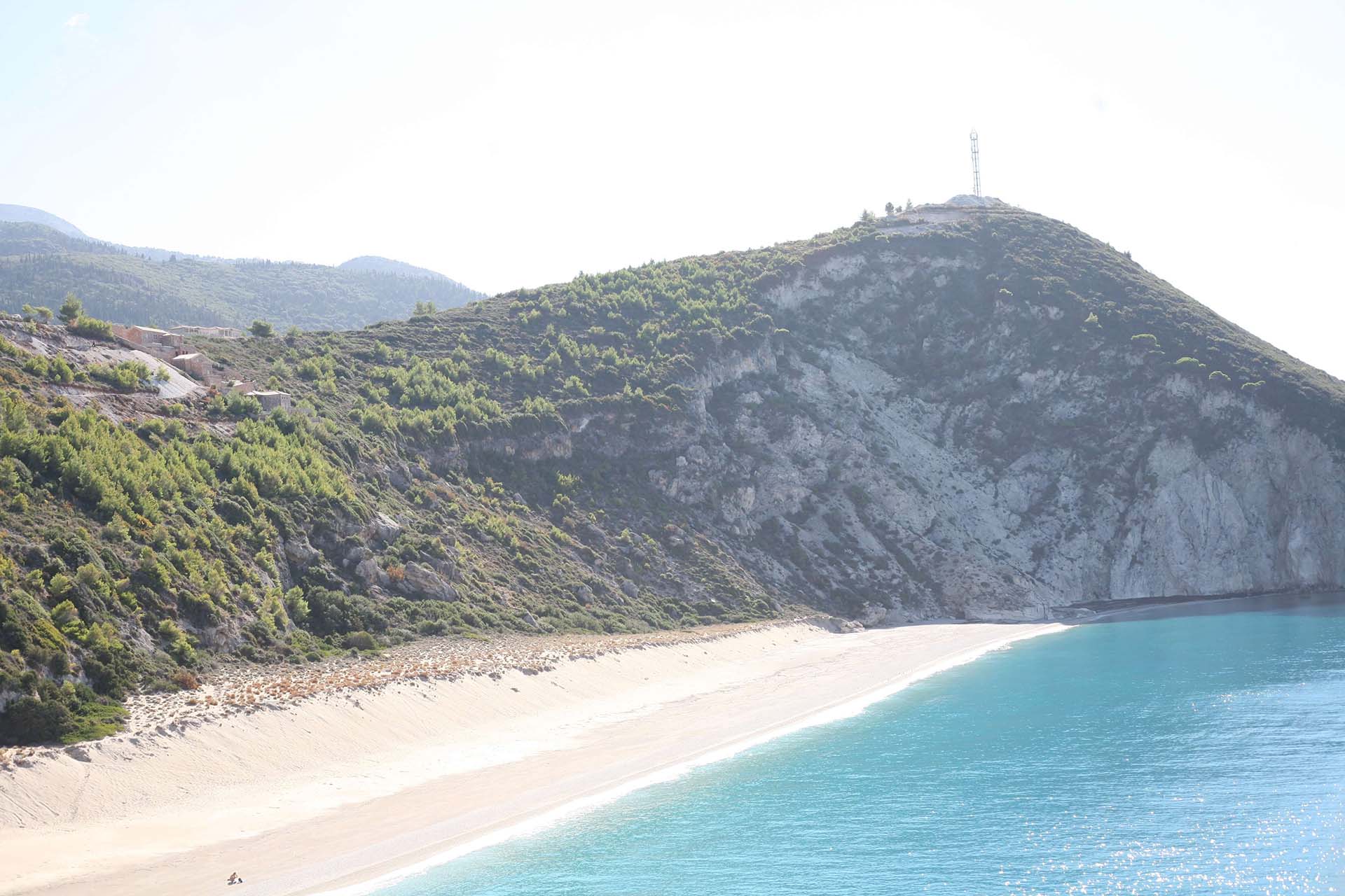Η εκπληκτική πανοραμική θέα της απέραντης παραλίας του Μύλου, με τα εμβληματικά τυρκουάζ νερά και τους απόκρημνους βράχους.