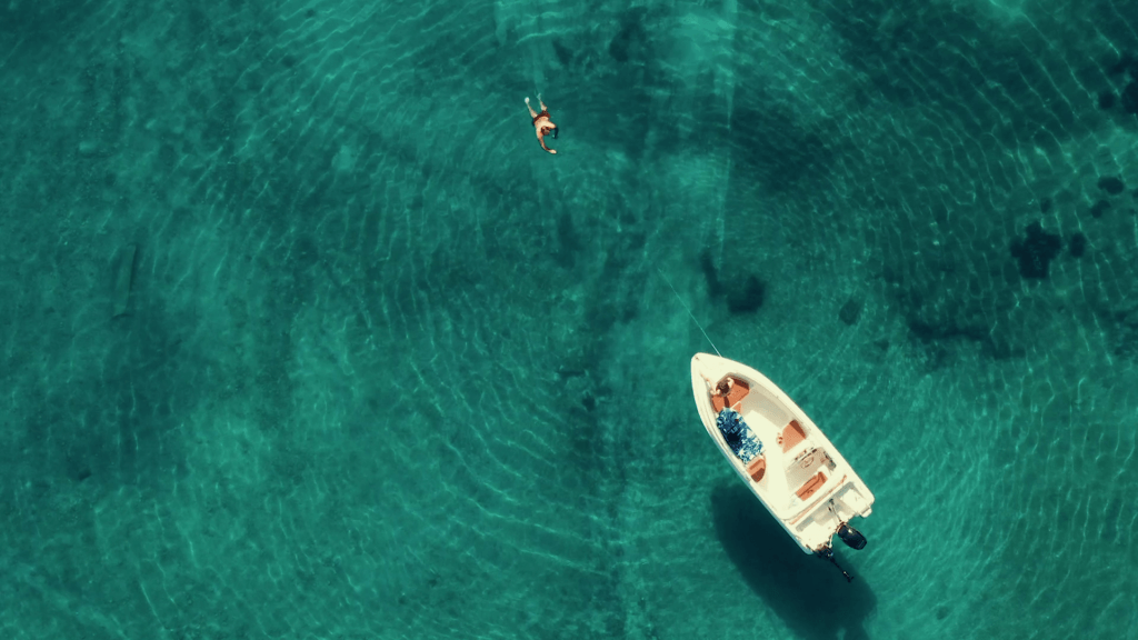 A family or group of friends enjoying a day on a license-free rental boat from Flisvos Boats in the turquoise Ionian Sea.