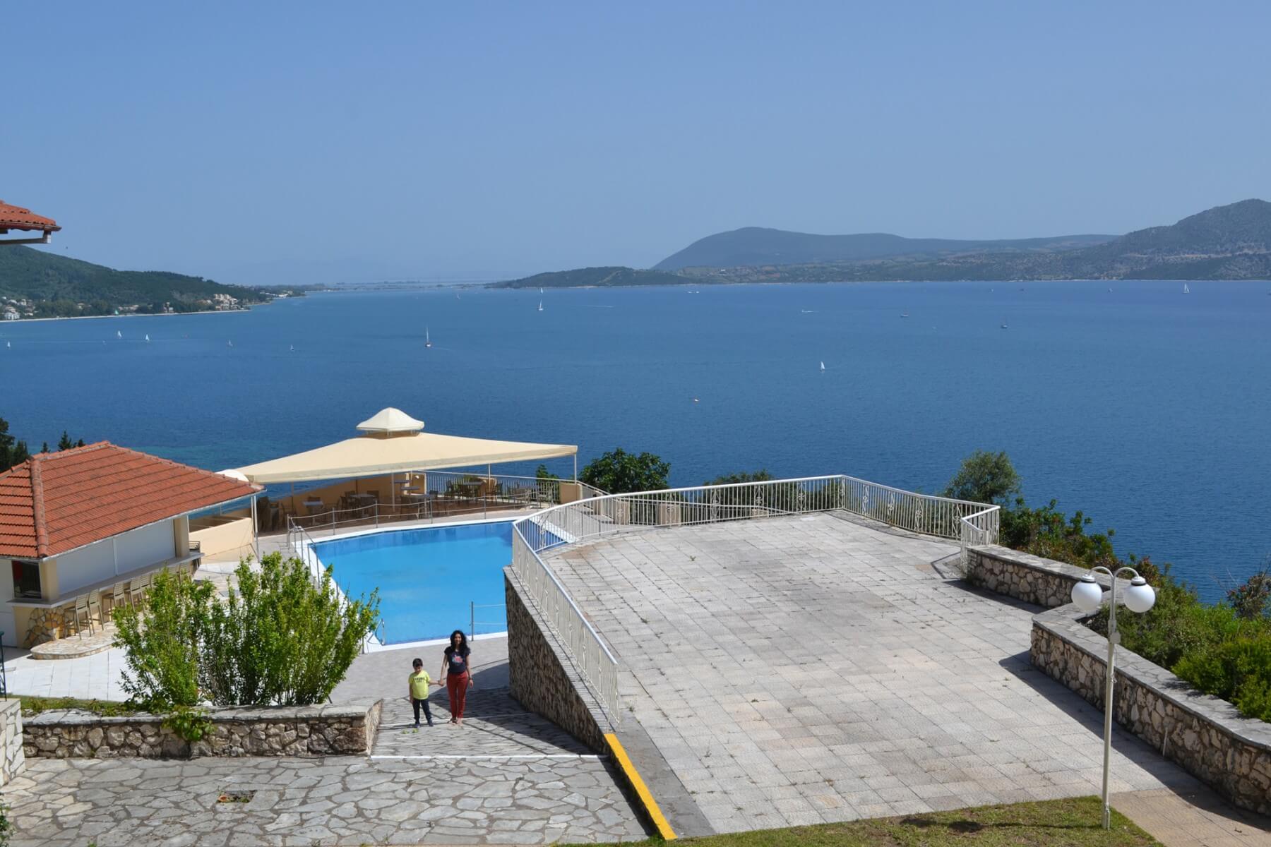 The stunning swimming pool at Sunrise Hotel in Nikiana, with panoramic views of the sea and mountains.