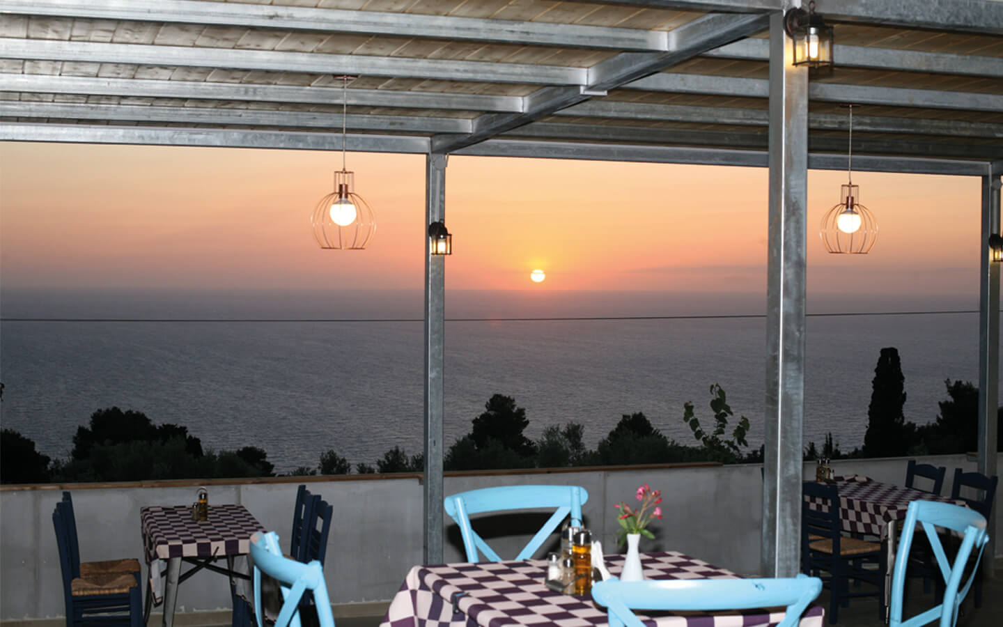 Η εκπληκτική θέα του ηλιοβασιλέματος πάνω από το Ιόνιο Πέλαγος από τη βεράντα της Ταβέρνας Αύρα στο Αθάνι Λευκάδας.