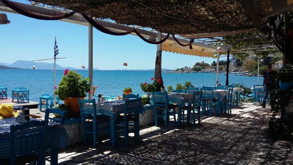 Η Ταβέρνα Seven Islands στη Λυγιά Λευκάδας, με φιλόξενα τραπέζια στρωμένα ακριβώς δίπλα στη θάλασσα, προσφέροντας γραφική θέα στο λιμάνι.